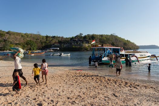 BALI, NUSA PENIDA ISLAND, INDONESIA - JULY 27.2015: Men transports cargo from ship in the hands. There is no other possibility to transport. Nusa Penida July 27. 2015 Indonesia
