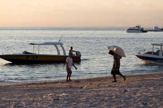 BALI, NUSA PENIDA ISLAND, INDONESIA - JULY 27.2015: Men transports cargo from ship in the hands. There is no other possibility to transport. Nusa Penida July 27. 2015 Indonesia