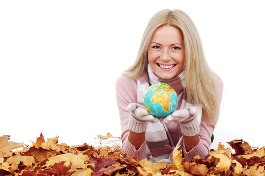 Woman with globe laying on dry autumn leaves isolated on white