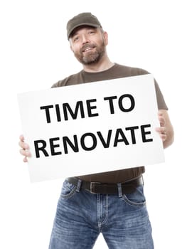 A bearded man holding a white board with the message time to renovate