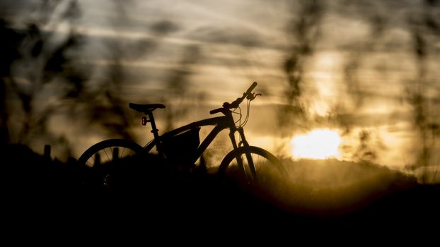 Silhouette of mountain bike with sunset light, Trave by bicycle concept