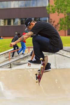 CALGARY, CANADA - JUN 21, 2015: Athletes have a friendly skateboard competition in Calgary. California law requires anyone under the age of 18 to wear a helmet while riding a skateboard.