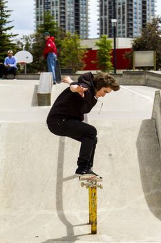 CALGARY, CANADA - JUN 21, 2015: Athletes have a friendly skateboard competition in Calgary. California law requires anyone under the age of 18 to wear a helmet while riding a skateboard.