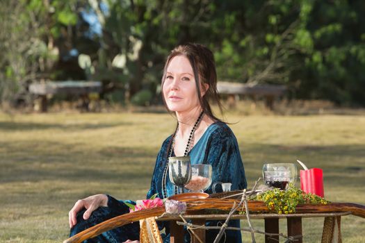 Pagan woman adult with altar sitting outdoors