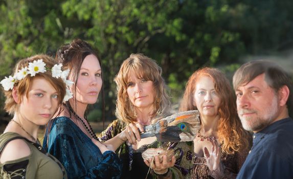 Five witches with feather and sage incense outdoors