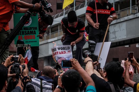 MALAYSIA, Kuala Lumpur: Protesters burn pictures at a rally in front of US Embassy in Kuala Lumpur, Malaysia on October 2, 2015. Protesters urge Americans to act against its ally Israel following clashes at Al-Aqsa mosque, between Israeli security forces and Palestinians Muslims.These pictures show hundreds of people holding signs, banners and waving flags as they parade in the Malaysian capital.
