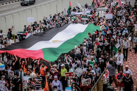 MALAYSIA, Kuala Lumpur: Demonstrators hold up a large flag during a rally in front of US Embassy in Kuala Lumpur, Malaysia on October 2, 2015. Protesters urge Americans to act against its ally Israel following clashes at Al-Aqsa mosque, between Israeli security forces and Palestinians Muslims.These pictures show hundreds of people holding signs, banners and waving flags as they parade in the Malaysian capital.