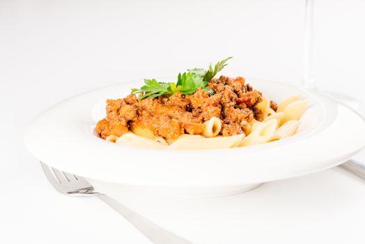 Pasta. Penne Pasta with Bolognese Sauce, Parmesan Cheese and Basil, Fork. Italian Cuisine. Mediterranean food