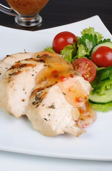 Slices of chicken breast grilled with vegetables and sauce