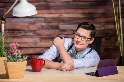 Easygoing lesbian business person leaning over at desk