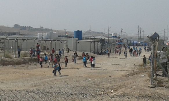 IRAQ, Kurdistan: A wide shot of the Kawergosk refugee camp in Kurdistan on October 1, 2015 as children walk to school. Syrian refugee students attend school on the second day of new year study.Thousands of refugees have been forced to flee Syria as a result of the civil war which has been raging for more than four years.  