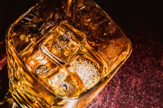 top of view of glass of whiskey on wood table with focus on ices, warm atmosphere, time of relax with whisky with space for text