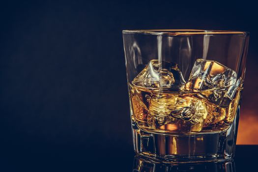 glass of whiskey on black background with reflection, warm atmosphere, time of relax with whisky with space for text