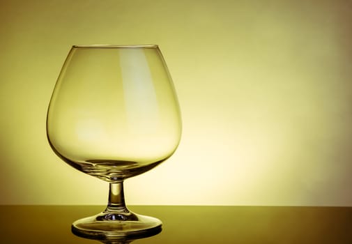 empty snifter of brandy in elegant typical cognac glass on table on warm atmosphere