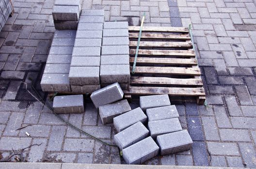 Pallet with few rows of concrete grey pavement blocks bricks in street