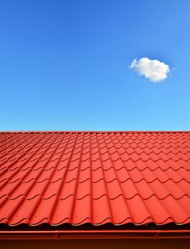 new roof with orange red sheet metal and background of blue sky