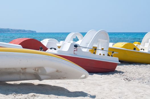 Series of boats with a slide on the beach waiting to sail