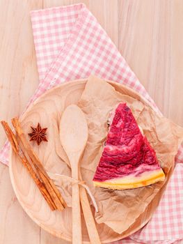 Homemade raspberry cake with cup of coffee on wooden background.