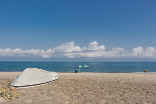 The boat on the lonely beach of fine sand