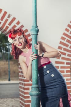 View of pinup young woman in vintage style clothing peeking on a playful way.