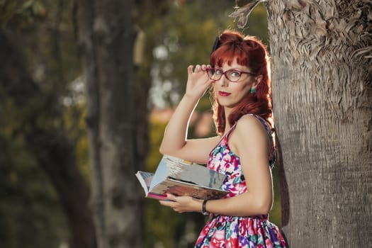 View of pinup young woman in vintage style clothing reading a book.
