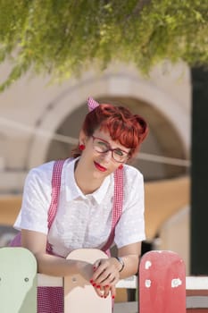 View of pinup young woman in vintage style clothing on the streets of Faro city.