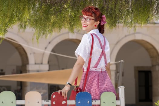 View of pinup young woman in vintage style clothing on the streets of Faro city.