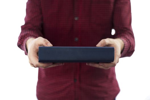 Man holding large closed book with blank spine, isolated on a white background