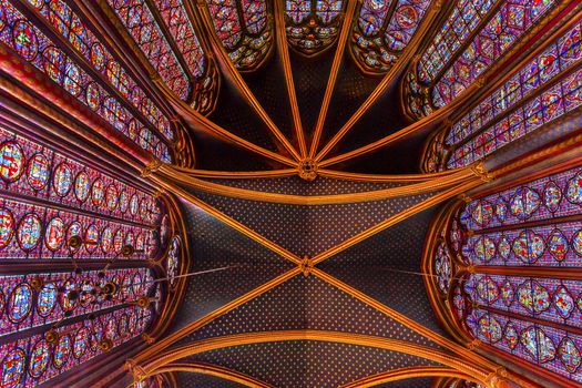 Stained Glass Cathedral Ceiling Saint Chapelle Paris France.  Saint King Louis 9th created Sainte Chapelle in 1248 to house Christian relics, including Christ's Crown of Thorns.  Stained Glass created in the 13th Century and shows various biblical stories along wtih stories from 1200s.