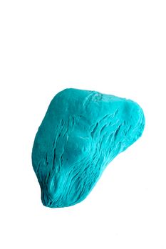 A piece of blue soap, well used, lies on a white background, showing all the lines and marks of use.