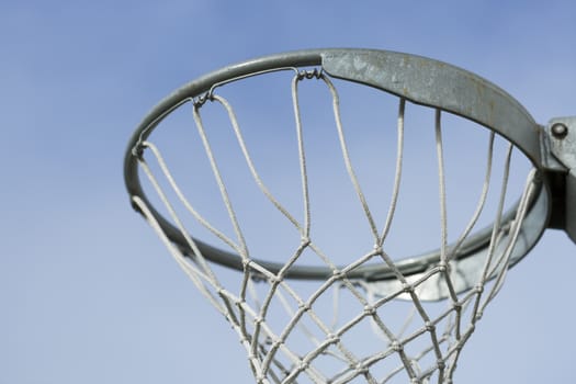Basket Ball Hoop with blue sky behind it.