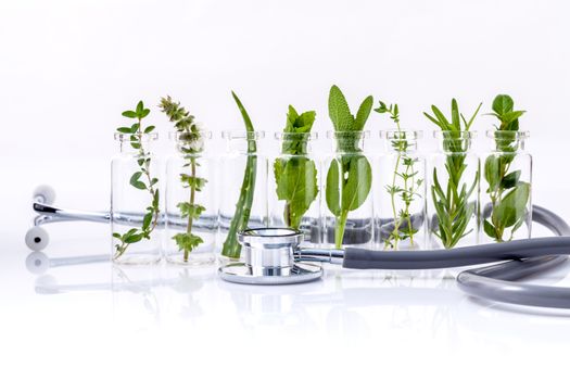 Bottle of essential oil with herb holy basil leaf, rosemary,oregano, sage,basil and mint with stethoscope on white background.