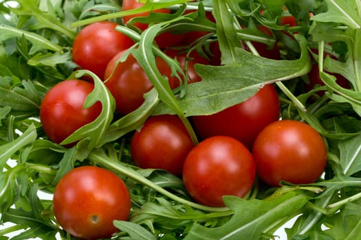 Heap of ruccola leaves and cherry tomatoes