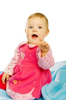 Cheerful baby girl in a dress sitting on the floor