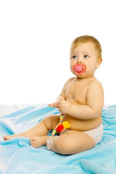 baby in diapers with a pacifier sitting on the floor