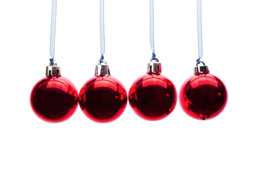 Four red christmas balls hanging in a horizontal row isolated on white background