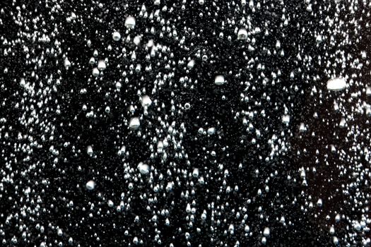 Air bubbles in the water on a black studio background