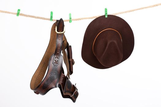 Wide brimmed hat and western belt hanging on a clothesline