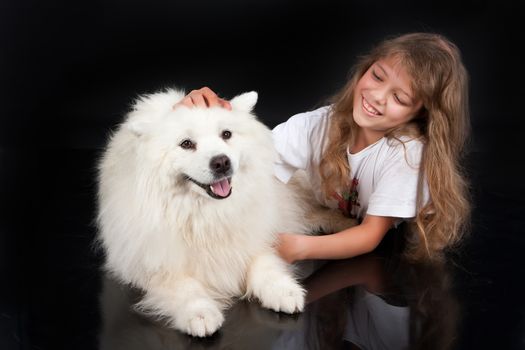 Girl and white Samoyed dog in the studio