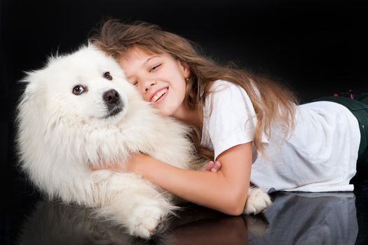 Girl and white Samoyed dog in the studio