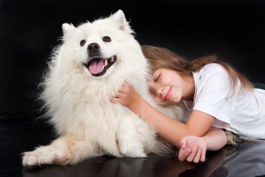 Girl and white Samoyed dog in the studio