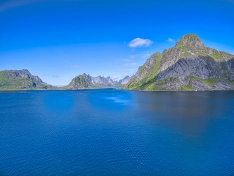 Scenic low aerial view of fjord on Lofoten islands surrounded by magnificent peaks