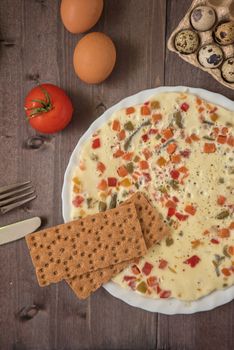 baked omelette with different eggs and vegetables with rye small load of bread