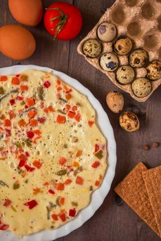 baked omelette with different eggs and vegetables with rye small load of bread