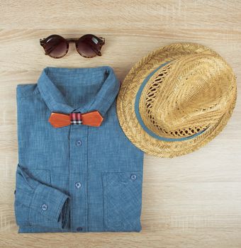 Top view collection of summer male clothing on the wooden background