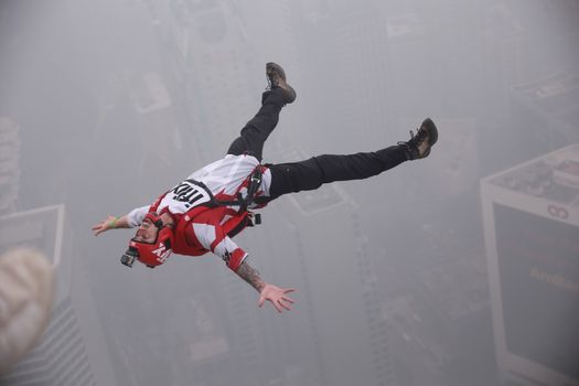 MALAYSIA, Kuala Lumpur: Base jumper backflips	Heavy haze didn't deter the 120 thrill-seeking base jumpers as they leapt into the foggy abyss off Kuala Lumpur Tower on October 3, 2015.  	The participants were joining others across the world on the 15th�International Base Jump Day. 