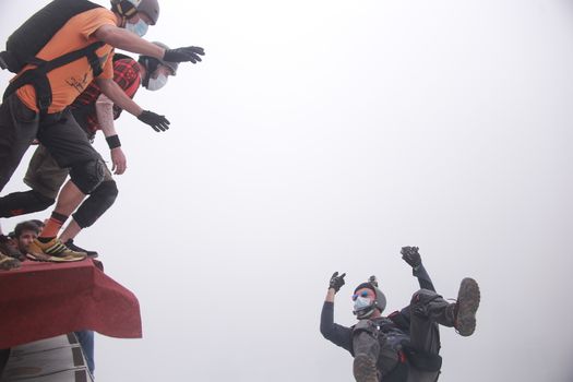 MALAYSIA, Kuala Lumpur: Base jumper signs to other jumping right after	Heavy haze didn't deter the 120 thrill-seeking base jumpers as they leapt into the foggy abyss off Kuala Lumpur Tower on October 3, 2015.  	The participants were joining others across the world on the 15th�International Base Jump Day. 