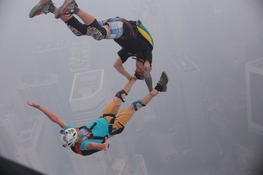 MALAYSIA, Kuala Lumpur: Base jumper pair leap	Heavy haze didn't deter the 120 thrill-seeking base jumpers as they leapt into the foggy abyss off Kuala Lumpur Tower on October 3, 2015.  	The participants were joining others across the world on the 15th�International Base Jump Day. 