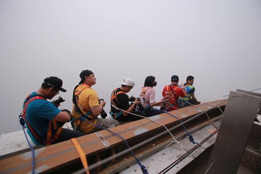 MALAYSIA, Kuala Lumpur: Photographer's anchored onto top of KL Tower	Heavy haze didn't deter the 120 thrill-seeking base jumpers as they leapt into the foggy abyss off Kuala Lumpur Tower on October 3, 2015.  	The participants were joining others across the world on the 15th�International Base Jump Day. 