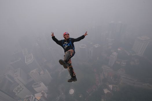 MALAYSIA, Kuala Lumpur: Base jumper 	Heavy haze didn't deter the 120 thrill-seeking base jumpers as they leapt into the foggy abyss off Kuala Lumpur Tower on October 3, 2015.  	The participants were joining others across the world on the 15th�International Base Jump Day. 